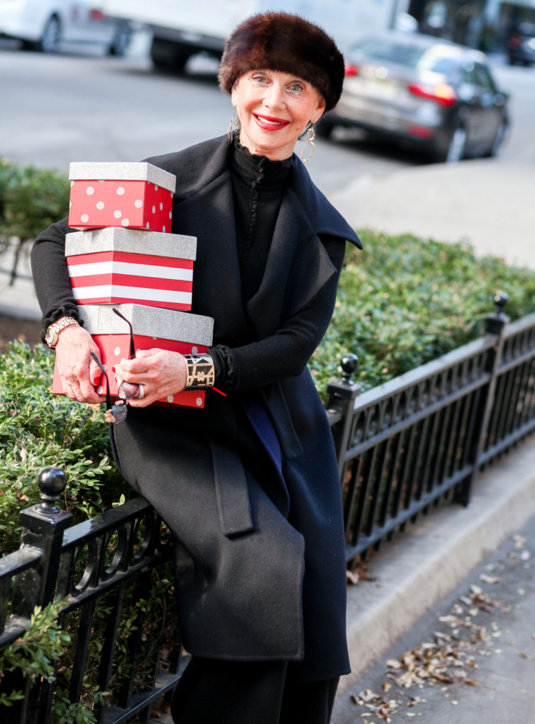 The Seasons of the Year, Honey Good smiling holding a stack of wrapped holiday gifts.