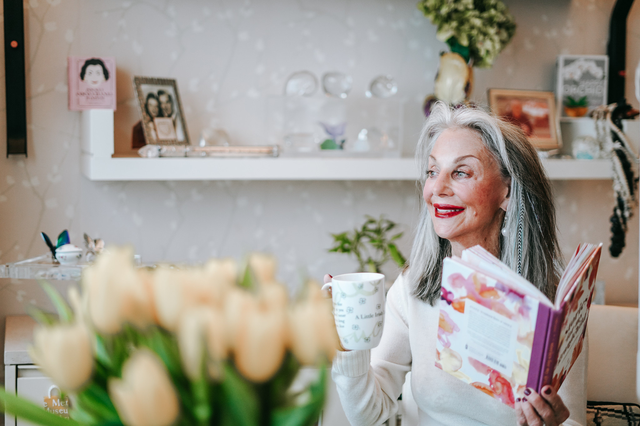 honey good looking out window holding mug and her book and not feeling lonely