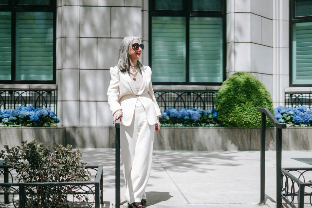 Image of Honey Good walking outside in a white suit finding joys in the little things Wellness over 50