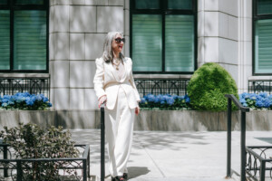 Image of Honey Good walking outside in a white suit finding joys in the little things