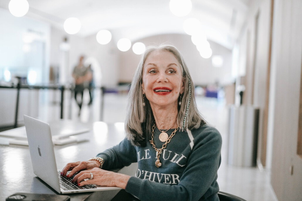 Image of honey good sitting at her computer in a public space as she pursues solitary pleasures after 50