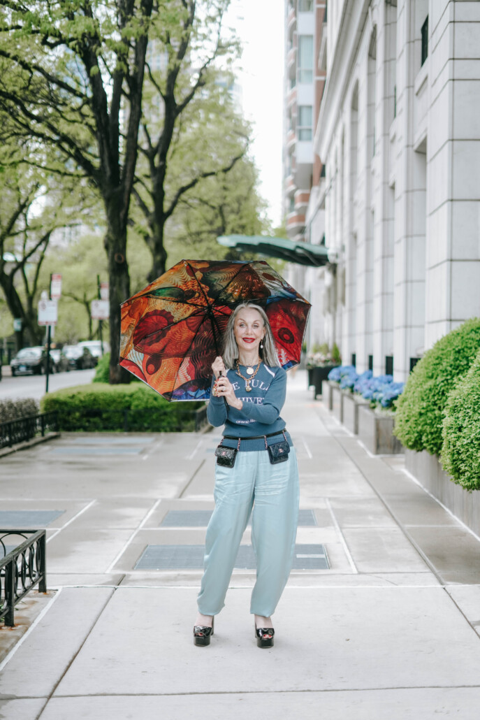 Image of Honey Good radiating style and avoiding fashion faux pas on the street holding a colorful umbrella.