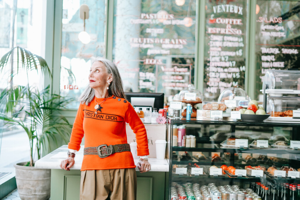 Honey Good, standing in a coffee shop looking pensive, contemplating feeling lonely and grandparent estrangement